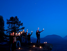 people standing in the dark holding candles
